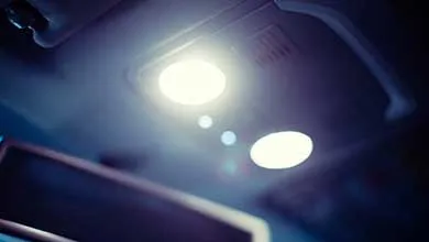 Two illuminated circular dome lights on a car's interior ceiling