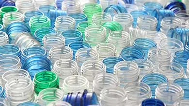 大量收集的蓝色、绿色和透明的空塑料瓶瓶口。